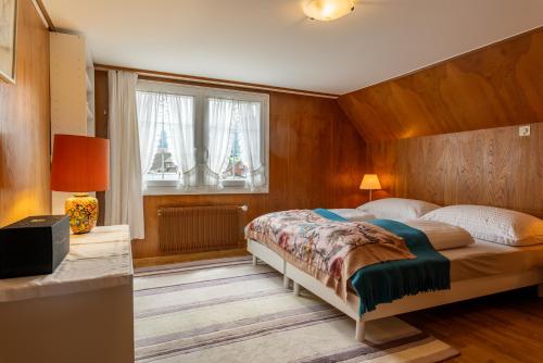 a bedroom with a large bed in a room with windows at Blattenheimat6 - im traditionellen Appenzeller Haus in Appenzell