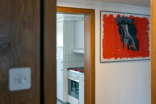 a door with a painting on it next to a kitchen at Blattenheimat6 - im traditionellen Appenzeller Haus in Appenzell