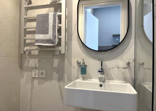 a bathroom with a white sink and a mirror at Glyfada Relax 8 in Athens