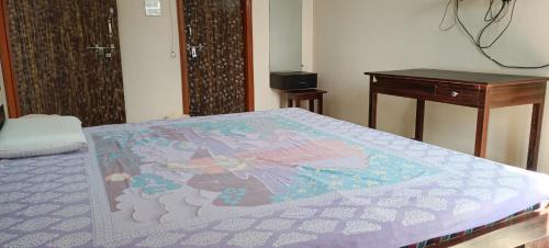 a bed in a room with a table and a bedspread at Govind Niwas Home Stay in Gwalior
