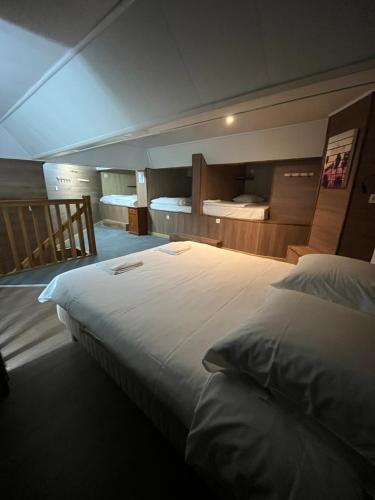 une chambre avec un grand lit blanc et une salle de bain dans l'établissement Loft avec 1H d'accès piscine spa, à Dijon