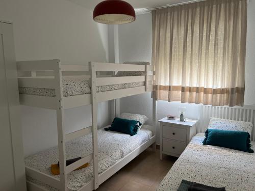 イスランティージャにあるApartamento en Islantilla playa con 2 terrazas y WIFI FIBRAの二段ベッド2台と机のある寝室