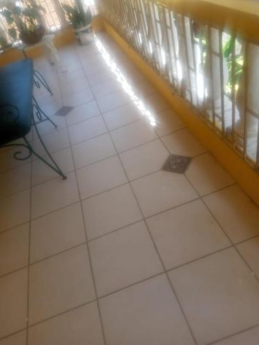 a room with a white tile floor and a balcony at Mumatt’s Guesthouse in Port Antonio