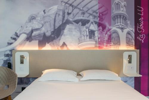 Ένα ή περισσότερα κρεβάτια σε δωμάτιο στο Brit Hotel Nantes Vigneux - L'Atlantel