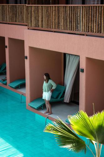 a woman standing on a bunk bed next to a pool at Arrey Boutique Hotel in Barra Grande