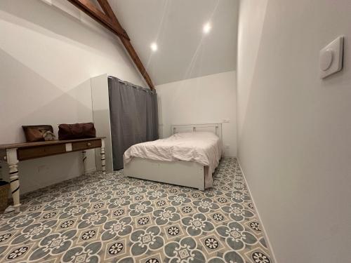 a bedroom with a bed and a tiled floor at Les jardins de Reville in Réville