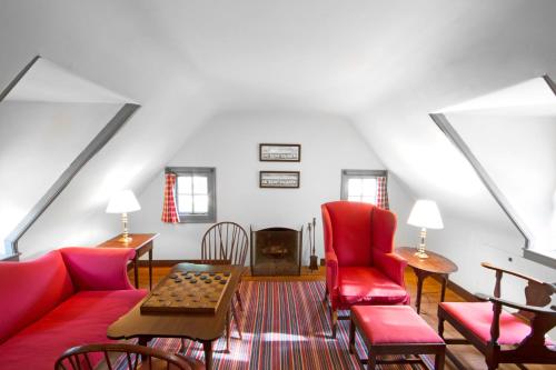 a living room with a red couch and chairs at Colonial Houses, an official Colonial Williamsburg Hotel in Williamsburg