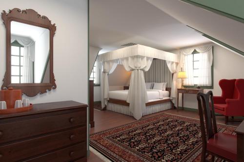 a bedroom with a canopy bed and a mirror at Colonial Houses, an official Colonial Williamsburg Hotel in Williamsburg