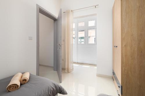 una camera da letto con un letto con due asciugamani sopra di Modern 2BD Apartment with Maltese Balcony & Back Yard - Close to St Julian's & St Georges Bay & Sliema Promenade a Il-Gżira