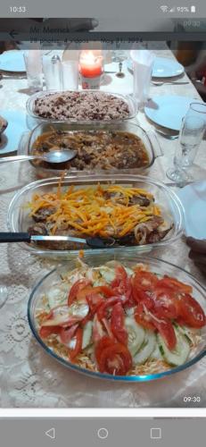 a table with many plates of food on it at Mumatt’s Guesthouse in Port Antonio