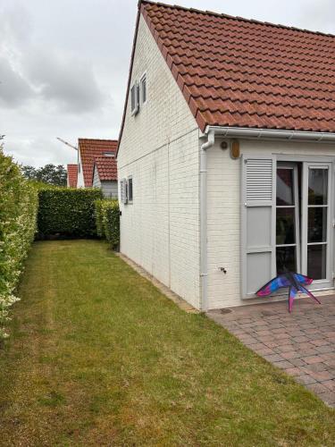 デ・ハーンにあるHouse 49, 3 Slaapkamers, 6 personenの家の庭で凧が飛んでいる