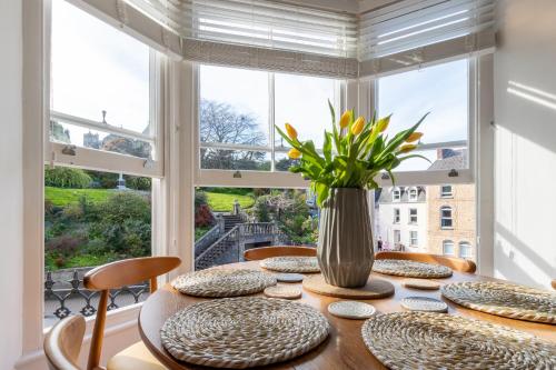 Un comedor con una mesa y un gran ventanal. en Flat 1, Church House, en Ilfracombe
