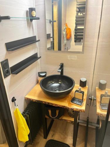 une salle de bain avec un lavabo noir et un miroir dans l'établissement Appartement charmant - Chamrousse - 36 m² - Vue montagne, à Chamrousse