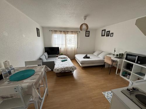 a living room with a couch and a table at Coeur de Perros-Guirec - Studio in Perros-Guirec
