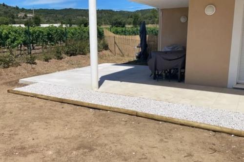 a porch of a house with a table and a fence at super appart au cœur des vignes in Péret