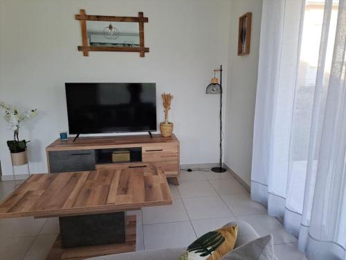 a living room with a flat screen tv on a table at super appart au cœur des vignes in Péret