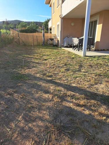 a yard with a fence and a house at super appart au cœur des vignes in Péret