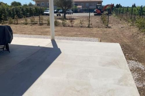 a pole on a patio with a table and a chair at super appart au cœur des vignes in Péret