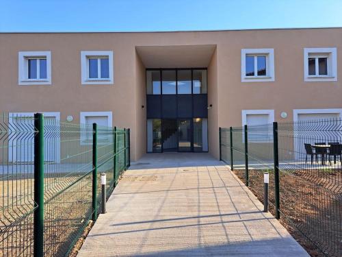 a building with a fence in front of it at super appart au cœur des vignes in Péret
