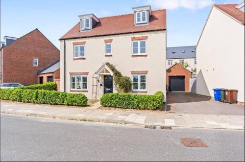 a large white house with a driveway at Luxury 5 bed house with Hot Tub nr Bicester Village in Bicester
