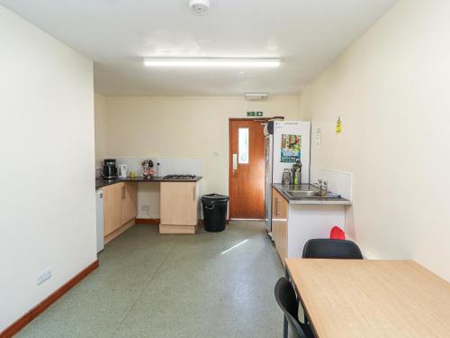 a room with a kitchen with a refrigerator and a table at Tor Hill in Peebles