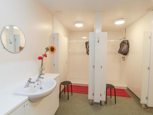 a white bathroom with a sink and a shower at Tor Hill in Peebles