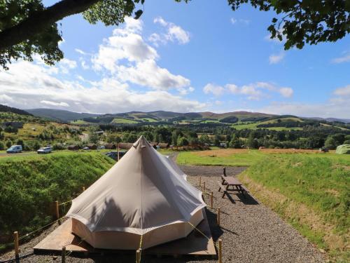 a bell tent in a field with mountains in the background at Kailzie in Peebles