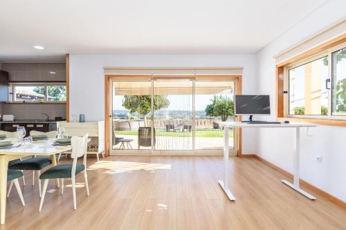 a kitchen and dining room with a table and a television at A Casa da Bela Vista in Aveiro