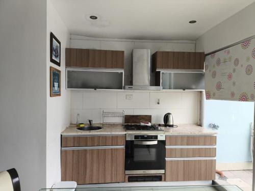 Una cocina con gabinetes de madera y un horno de estufa. en Casa Tunez, en Buenos Aires