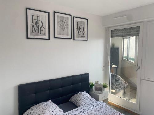 une chambre avec une tête de lit bleue et trois photos sur le mur dans l'établissement Belle Chambre a EVRY proche Gare RER, à Évry-les-Châteaux