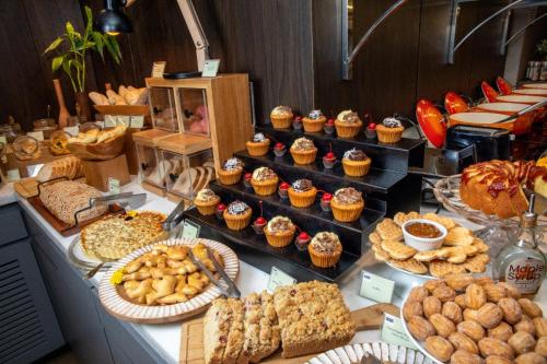 un buffet con muchos tipos diferentes de postres y repostería en ArtHotel Transamerica Collection, en Porto Alegre