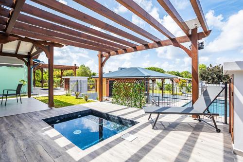 a patio with a pool and a pergola at Gîte Dalina in Saint-François