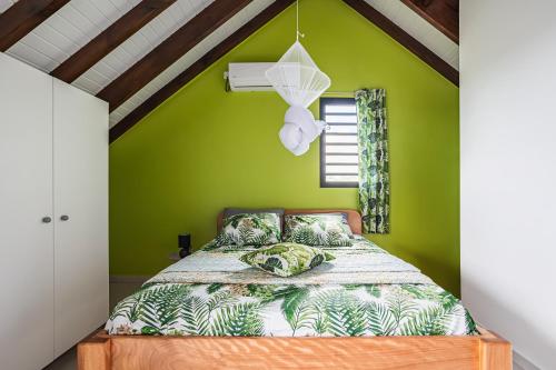 a bedroom with green walls and a bed at Gîte Dalina in Saint-François