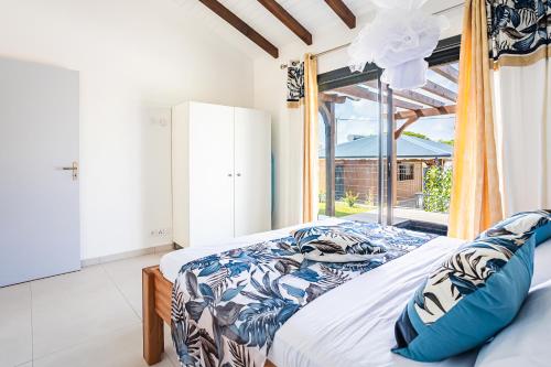 a bedroom with a bed and a large window at Gîte Dalina in Saint-François