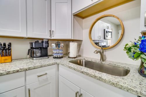 a kitchen with white cabinets and a sink and a mirror at Albuquerque Retreat with Hot Tub - Central Location! in Albuquerque