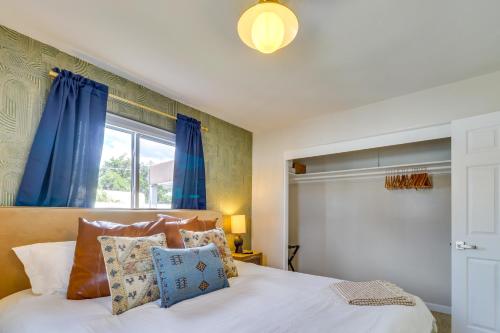 a bedroom with a bed with blue curtains and a window at Albuquerque Retreat with Hot Tub - Central Location! in Albuquerque