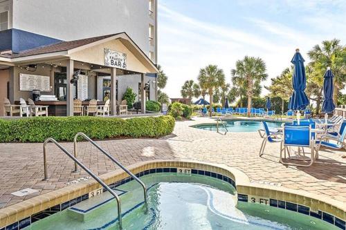 a pool at a resort with chairs and umbrellas at A Wave From It All in Myrtle Beach