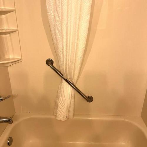 a shower curtain in a bathroom with a tub at A Wave From It All in Myrtle Beach