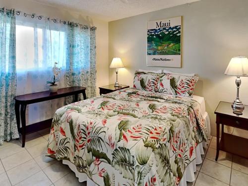 a bedroom with a bed and two lamps and a window at Menehune Shores 206 in Kihei