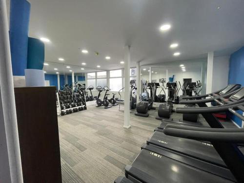 a gym with rows of treadmills and elliptical machines at Flat 406 One bedroom apartment in Birmingham