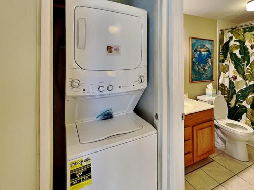 a white refrigerator in a bathroom with a sink at Menehune Shores 206 in Kihei
