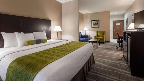 a hotel room with a large bed and a desk at Best Western Plus Denver City Hotel & Suites in Denver City
