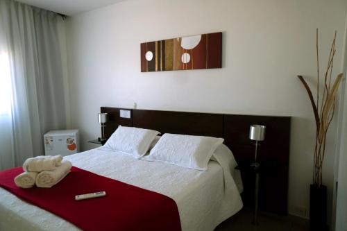 a bedroom with a bed with two towels on it at Hotel Oaky in Posadas