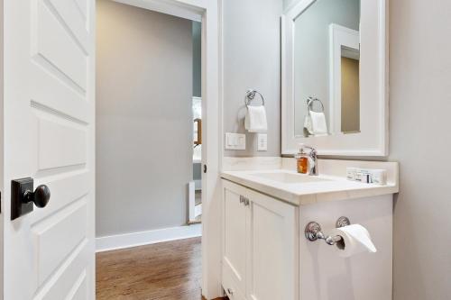 a white bathroom with a sink and a mirror at Peabody House in Wilmington