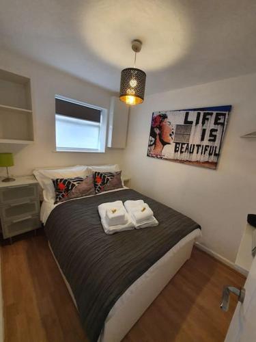 a bedroom with a bed with two towels on it at Crash pad in Luton Town in Luton