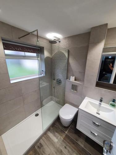 a bathroom with a shower and a toilet and a sink at Crash pad in Luton Town in Luton
