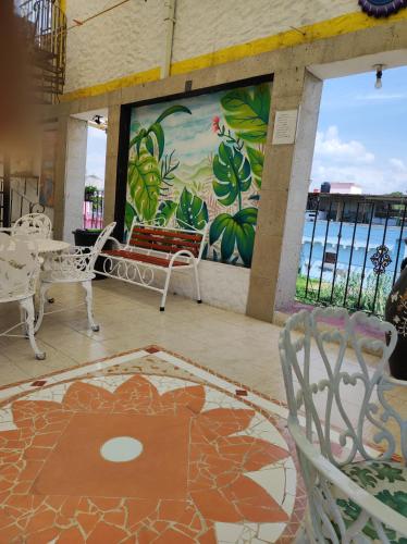 a room with a table and chairs and a mural at Hotel Colonial in Yautepec