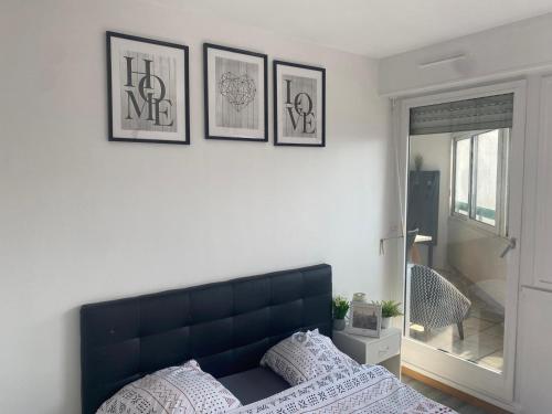 a bedroom with a bed and four pictures on the wall at Appartement 3 Chambres Evry plein Centre ville in Évry-les-Châteaux