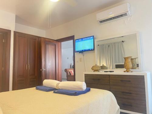 a bedroom with a bed and a tv on the wall at Stanza Mare Beach Front in Punta Cana