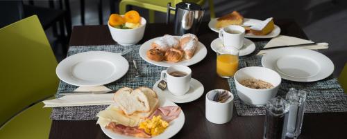 a table with plates of breakfast food on it at Hotel Europa in Breuil-Cervinia